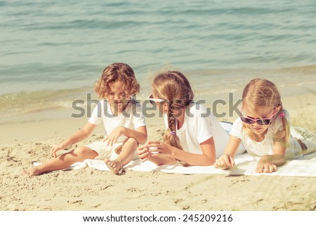 two sisters and brother playing on the beach at the day time