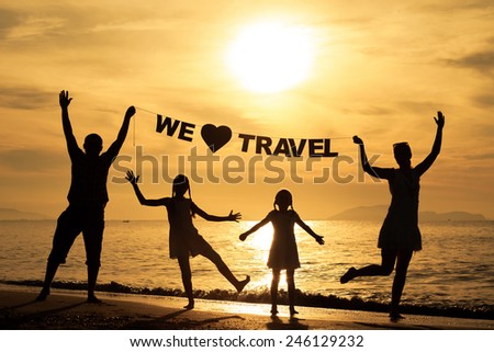 Happy family standing on the beach at the sunset time. Parents hold in the hands  inscription \
