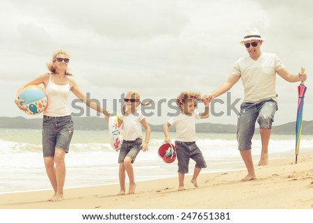 Happy family dancing on the beach at the day time. Concept of friendly family.