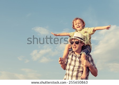 Dad and son playing near a house at the day time