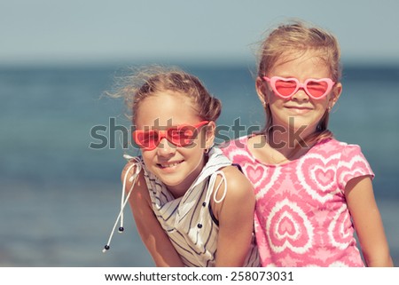 two sisters standing on the beach at the day time