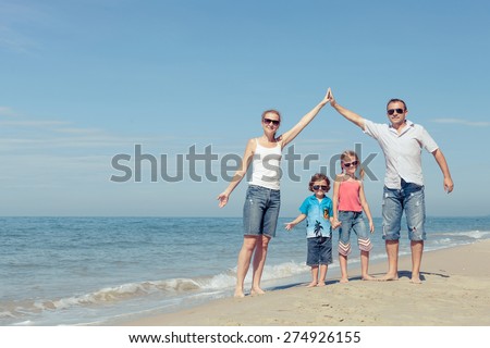 Happy family standing on the beach at the day time. Concept of friendly family.