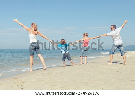 Happy family standing on the beach at the day time. Concept of friendly family.