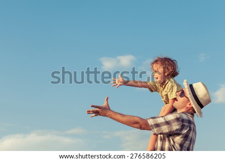 Dad and son playing near a house at the day time.