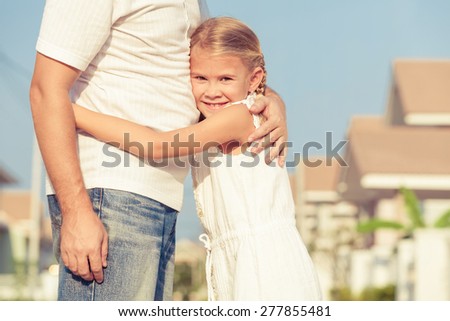 Dad and daughter  playing near a house at the day time. Concept of friendly family.