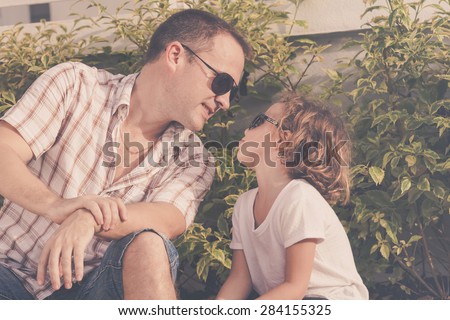 Dad and son playing near a house at the day time. Concept of friendly family.
