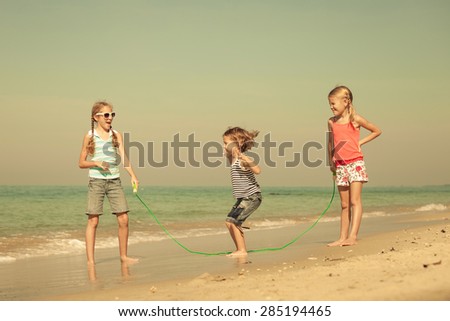 two sisters and brother playing on the beach at the day time.  Concept of friendly family.