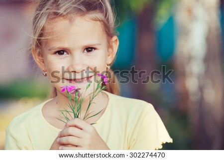 portrait of a beautiful young girl with wildflowers at the day time