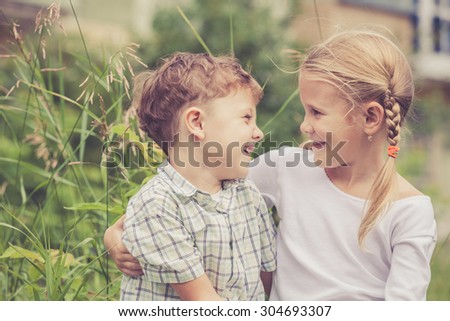 Two happy children  playing near the tree at the day time. Concept Brother And Sister Together Forever