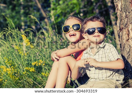 Two happy children  playing near the tree at the day time. Concept Brother And Sister Together Forever