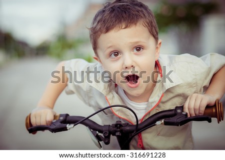 Happy little boy with bicycle at the day time