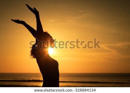 woman open arms under the sunset at sea. Concept of healthy life.