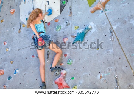 teenager climbing a rock wall indoor