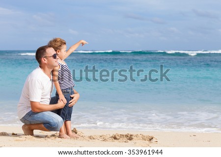 Happy father and son playing on the beach at the day time. Concept of friendly family.