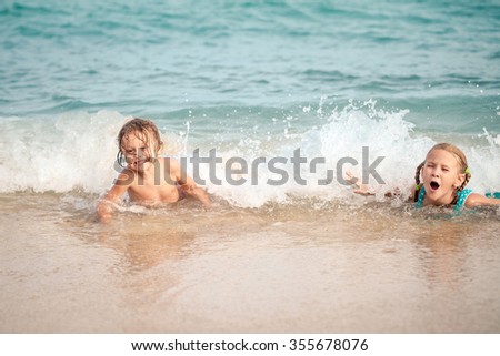 Sister and brother playing on the beach at the day time. Concept Brother And Sister Together Forever
