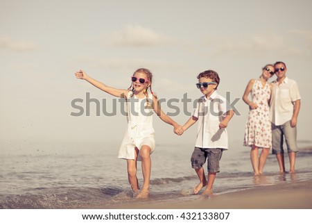 Happy family walking on the beach at the day time. Concept of friendly family.