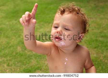 stained ice cream, a little boy holds up his index finger