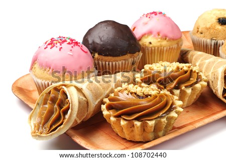 Cakes and cupcakes on a plate on white