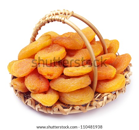 Dried apricots in a wicker basket on white