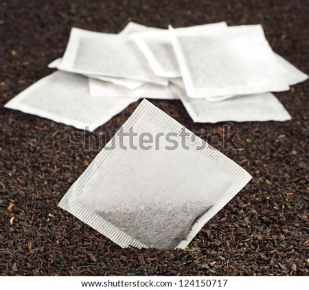Tea bags on the background of dry tea