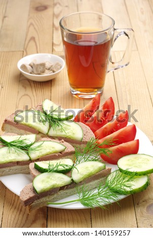 Sandwiches with liver sausage, cucumber, tomato and cup tea