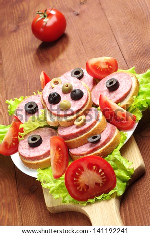 Sandwiches with sausage and vegetables on a cutting board