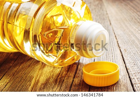 Vegetable oil in plastic bottle closeup on the old wooden table