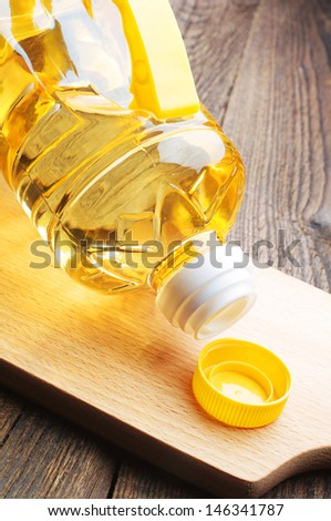 Vegetable oil in plastic bottle closeup on a cutting board
