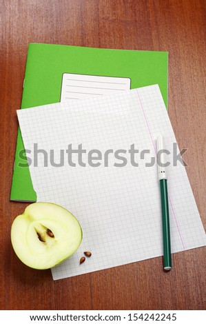 Blank sheet of school notebook, slice apple and felt-tip pens on table