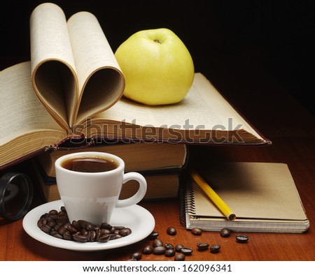 Cup of coffee, notepad, apple and opened book