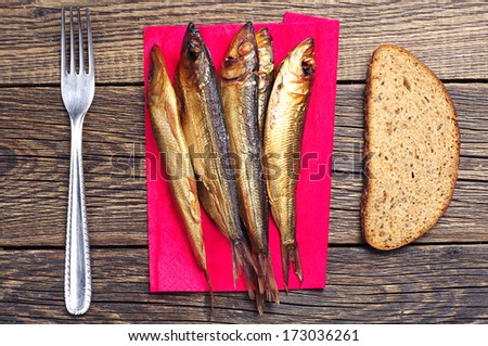 Smoked fish on board with a fork and bread