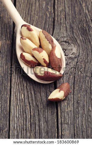 Brazil nuts in spoon on vintage wooden background
