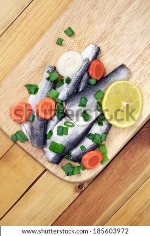 Marinated salted fish on a cutting board on table