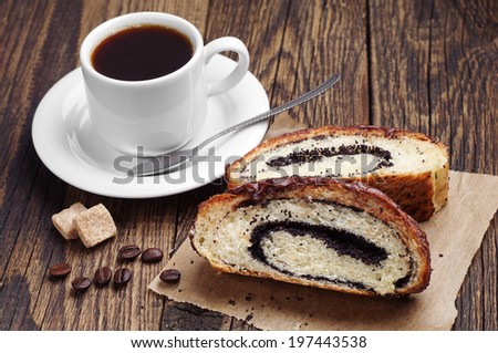 Cup of coffee and slice buns with poppy on wooden table