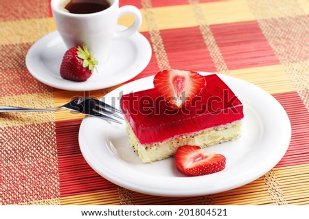 Strawberry cake with poppy and cup of coffee on colorful bamboo napkin