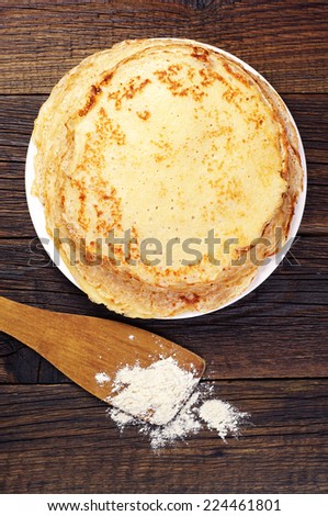 Stack of delicious pancakes on old wooden table. Top view