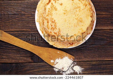 Tasty pancakes in a plate on vintage wooden table. Top view