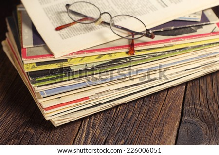 Old magazines and glasses on vintage wooden table