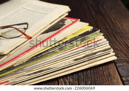 Old magazines and glasses on wooden table