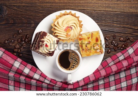 Plate with tasty cakes and coffee cup on old wooden table. Top view