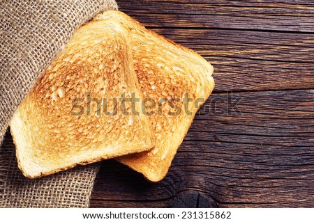 Roasted toast bread on wooden background closeup. Top view