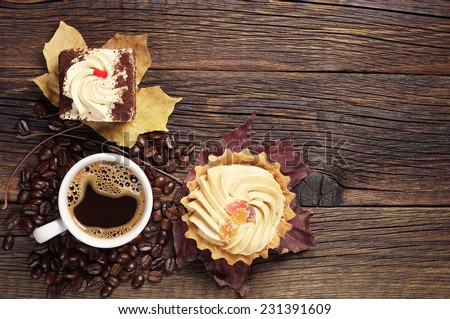 Two tasty cakes and cup of hot coffee on dark wooden table. Top view
