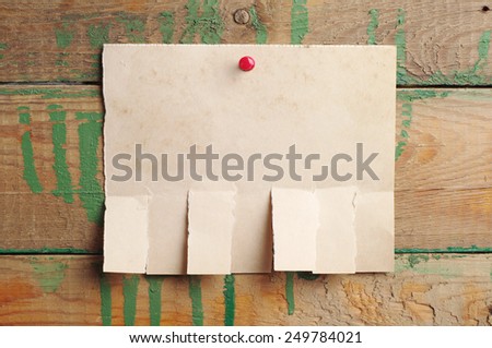 Torn paper for ads on old wooden background