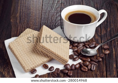 Coffee cup and wafers with chocolate on rustic wooden table