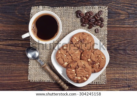 Coffee with chocolate cookies on dark wooden table from above