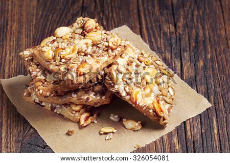 Sweet cookies with nuts, sesame and sunflower seeds on old wooden table