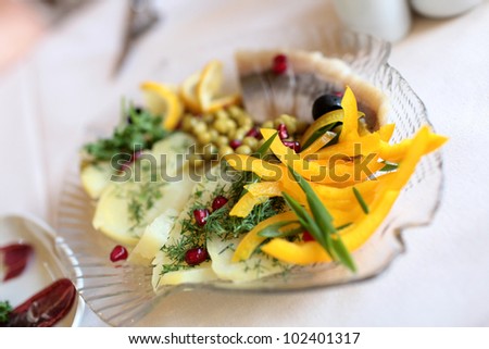 Vegetables and herring on plate in russian restaurant