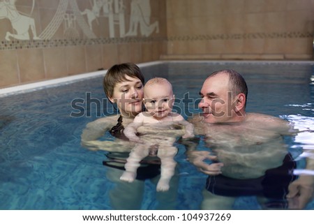 The family posing in an indoor swimming pool