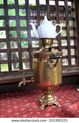 Copper samovar with white teapot in russian restaurant