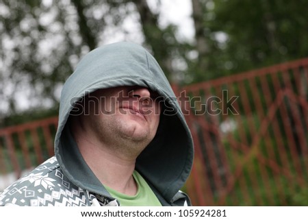 Portrait of man with hood in a park